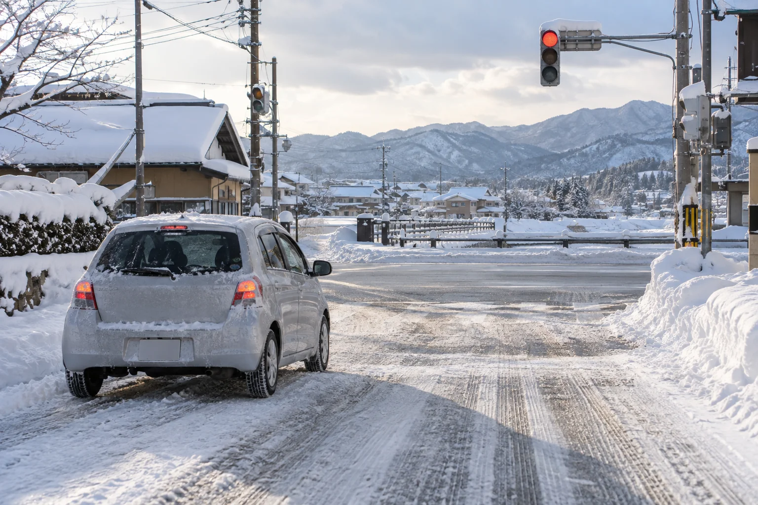 雪が残る市街地の交差点と停止線